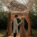 A Muslim couple under a decorative canopy during a wedding ceremony.